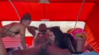 Dos mujeres sensuales practicando sexo oral en público en la playa